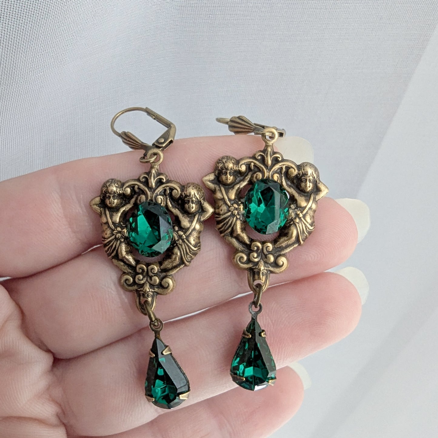 Matching brass earrings with emerald Swarovski crystals and floral scrollwork design