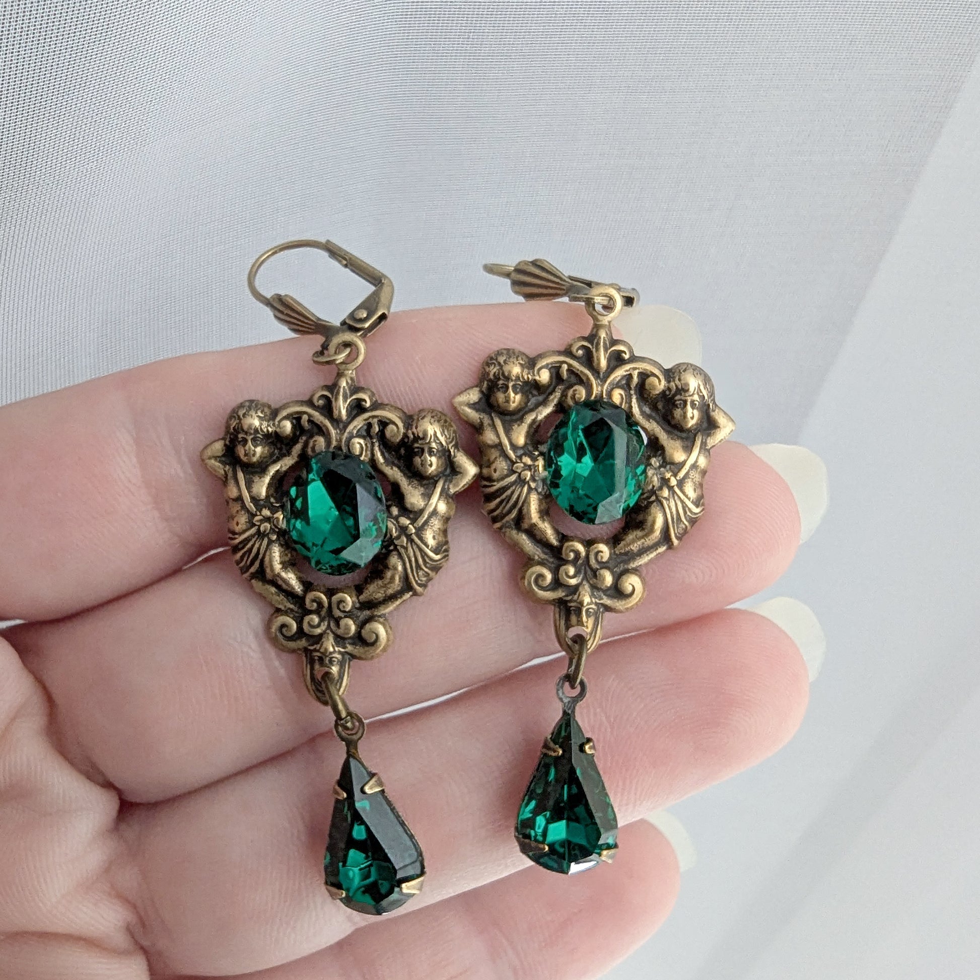 Matching brass earrings with emerald Swarovski crystals and floral scrollwork design