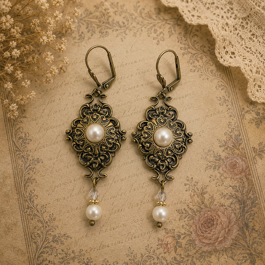 Pair of ornate earrings with pearls on an antique-style background