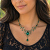 Woman wearing a decorative necklace with green gemstones.  vintage_emerald_Swarovski_crystal_floral_bridal_necklace_-_vintage_jewelry_-_wedding_jewelry_set