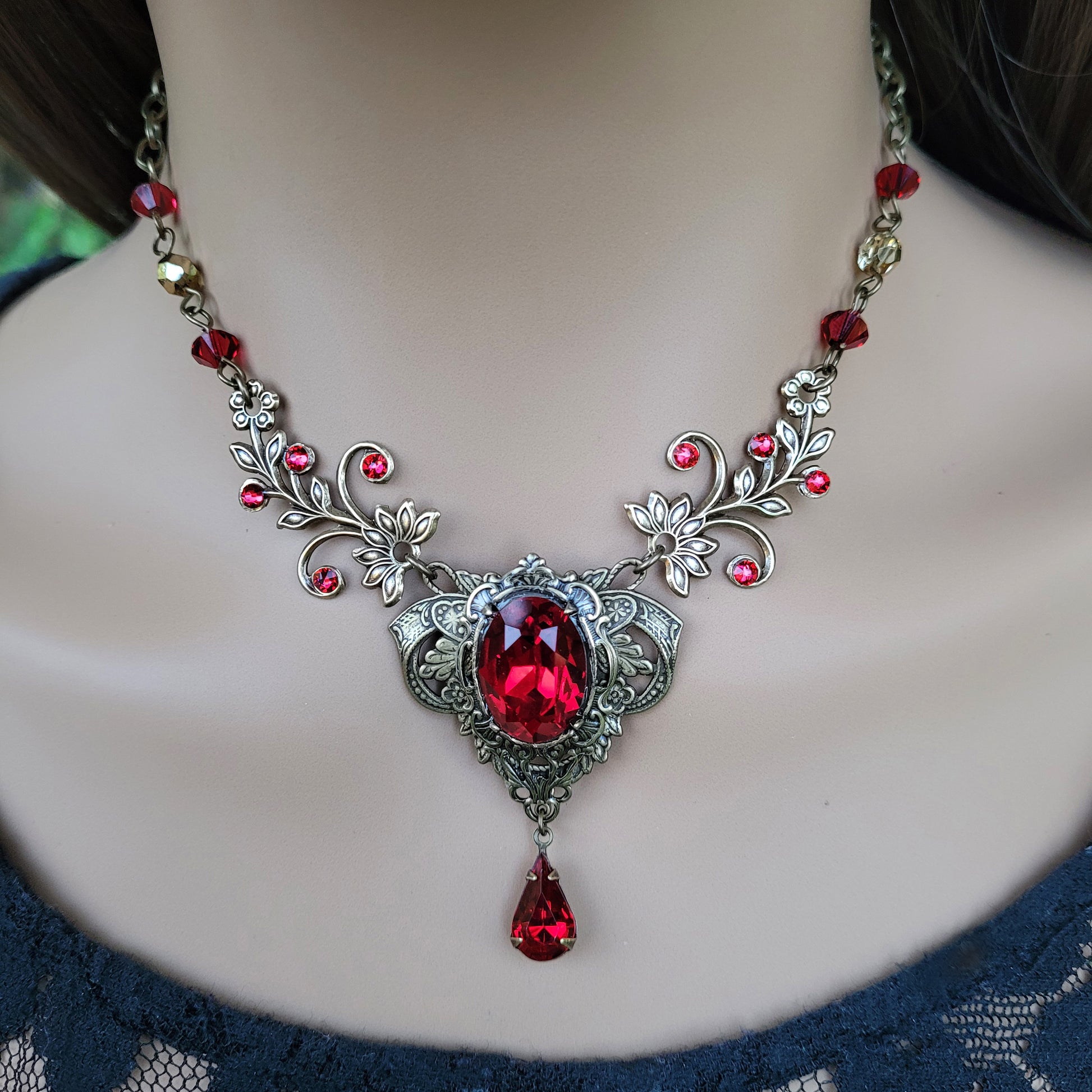 Woman wearing a vintage red Swarovski crystal necklace with intricate floral design.  Fairycore Vampire Jewelry Aesthetic.