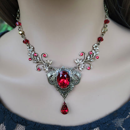 Woman wearing a vintage red Swarovski crystal necklace with intricate floral design.  Fairycore Vampire Jewelry Aesthetic.