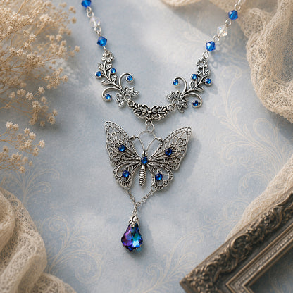 Butterfly necklace with blue gemstones on a textured surface.  Woodland Victorian jewelry