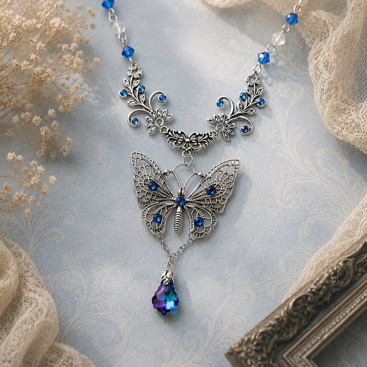 Butterfly necklace with blue gemstones on a textured surface.  Woodland Victorian jewelry