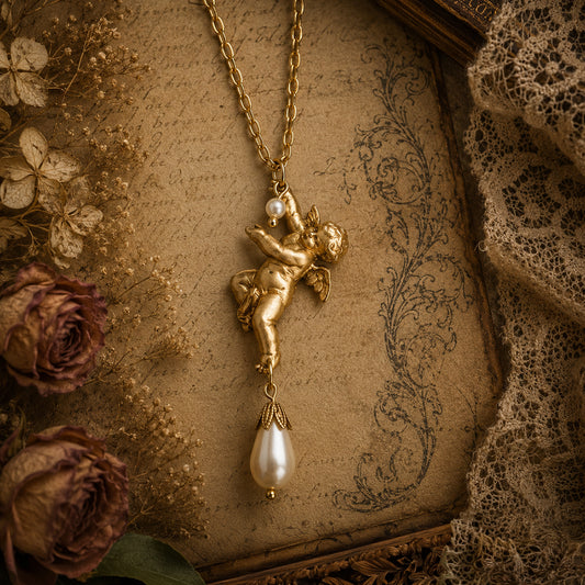 Gold angel pendant necklace with a pearl on an old book and floral background.  Vintage brass cherub pendant necklace with pearl