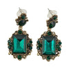 Vintage emerald green crystal earrings with a white background