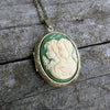 Vintage-style cameo necklace with two sisters on a wooden surface