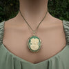 Vintage-style necklace with a green cameo pendant on a model against a natural background
