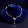 Pearl and crystal necklace on a blue velvet stand with a dark background