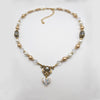 Vintage style bridal Necklace with pearls, crystals, and gold accents on a light gray background